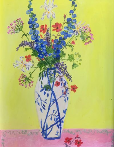 A blue and white floral vase filled with colourful flowers