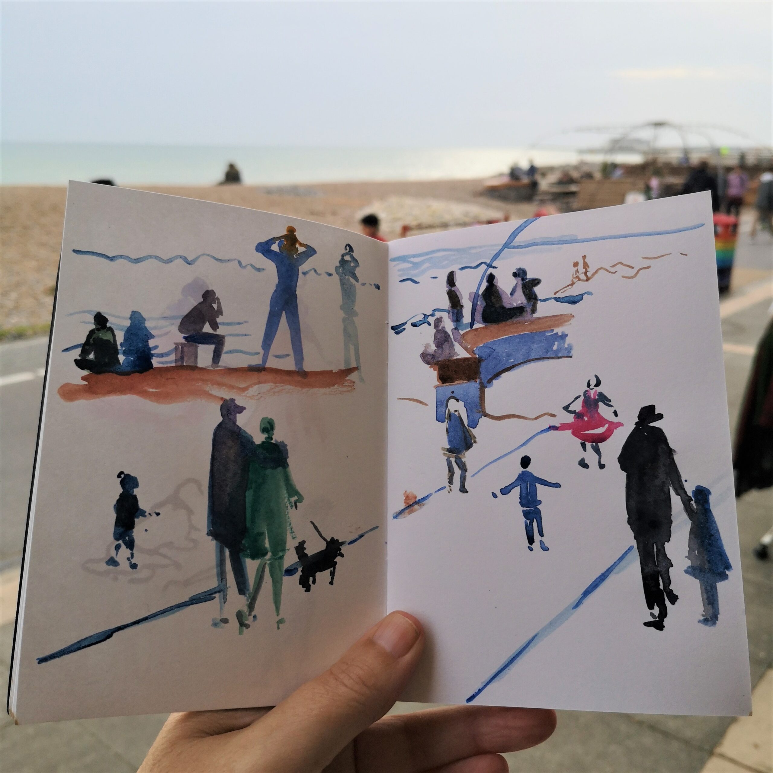 A photograph of Amanda's sketchbook capturing figures along the seafront